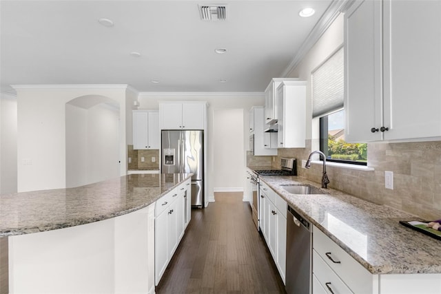 kitchen with ornamental molding, visible vents, a large island, appliances with stainless steel finishes, and a sink