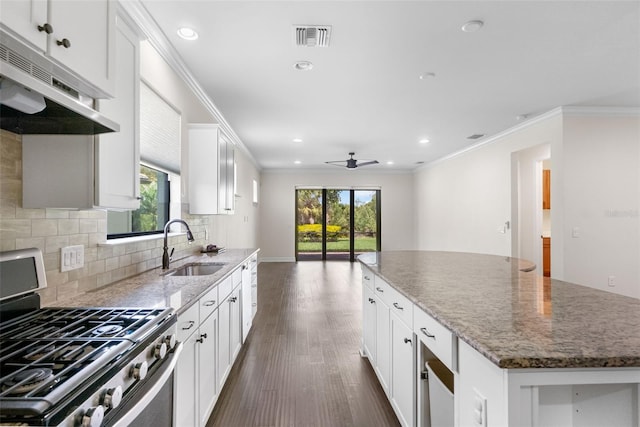 kitchen featuring visible vents, a sink, under cabinet range hood, crown molding, and stainless steel gas stove