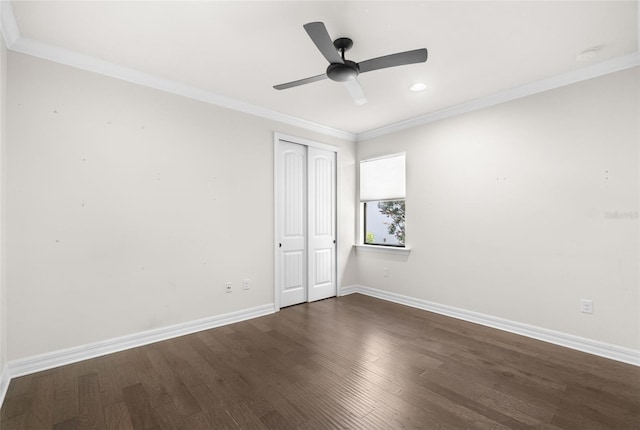 spare room with a ceiling fan, dark wood finished floors, baseboards, and ornamental molding