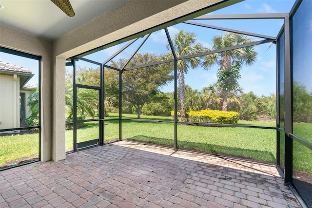 unfurnished sunroom with ceiling fan