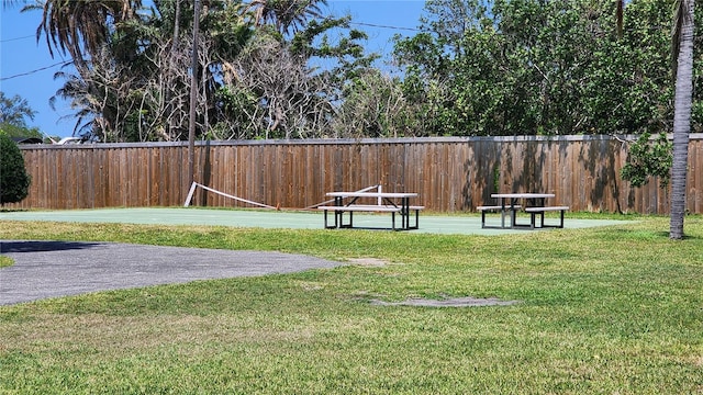 view of property's community featuring fence and a lawn