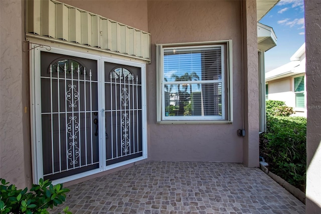 property entrance with stucco siding