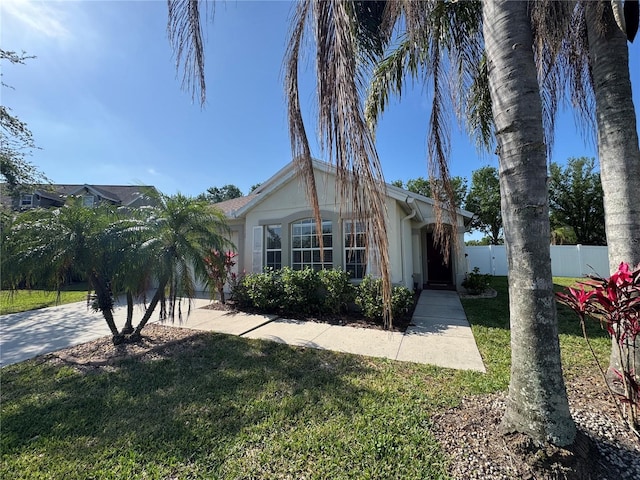 11811 53rd Ct E, Parrish, FL 34219 - view of front facade featuring a front yard, driveway, stucco siding, and fence