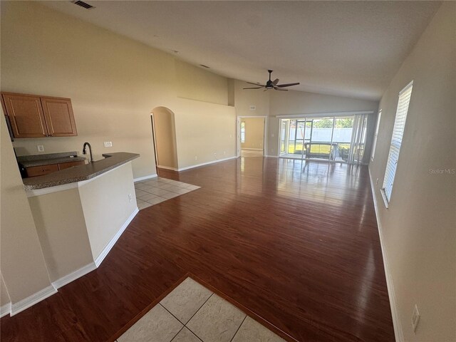 11811 53rd Ct E, Parrish, FL 34219 - unfurnished living room featuring high vaulted ceiling, light wood finished floors, baseboards, arched walkways, and ceiling fan