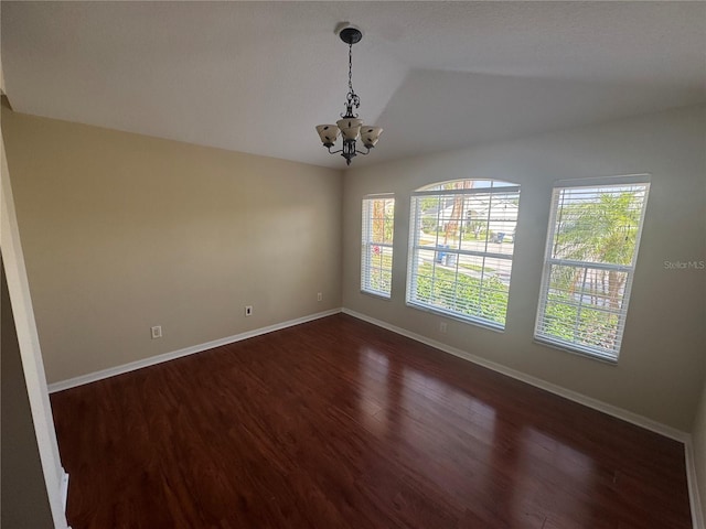 11811 53rd Ct E, Parrish, FL 34219 - empty room featuring plenty of natural light, a notable chandelier, dark wood-style floors, and vaulted ceiling