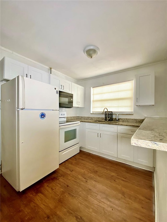 kitchen with white appliances, white cabinets, a sink, and dark wood-style flooring