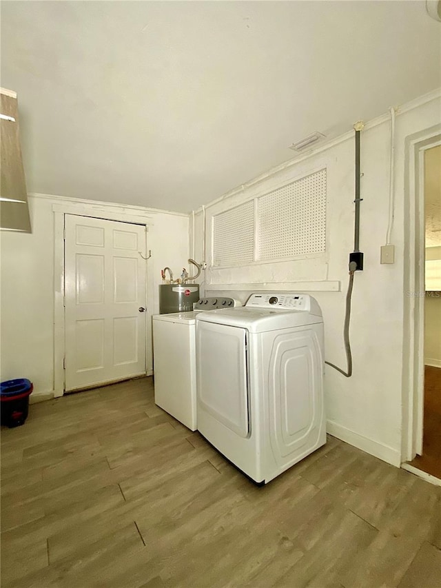 washroom with baseboards, laundry area, water heater, light wood-style floors, and washer and dryer