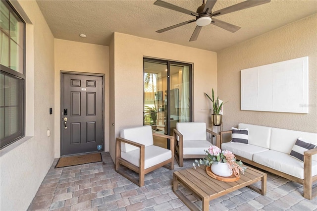 exterior space featuring an outdoor living space, ceiling fan, a patio area, and stucco siding