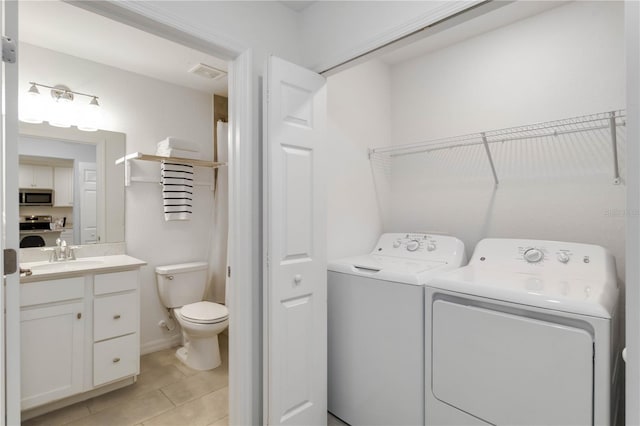 laundry area with laundry area, washer and clothes dryer, visible vents, a sink, and light tile patterned flooring