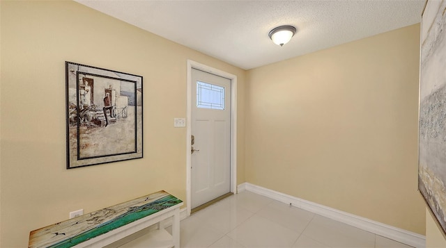 foyer entrance with a textured ceiling and baseboards