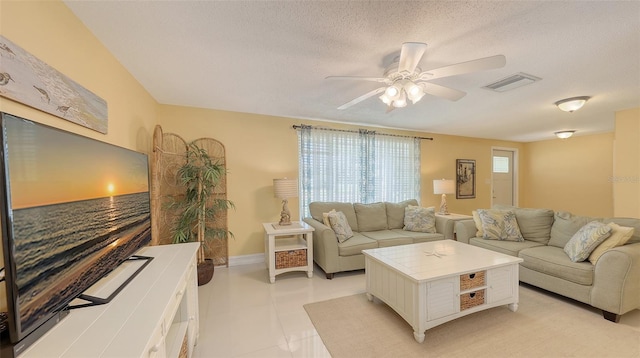 living room featuring a textured ceiling, visible vents, a ceiling fan, and light tile patterned floors