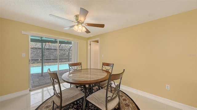 dining area with a sunroom, light tile patterned floors, a ceiling fan, baseboards, and a textured ceiling