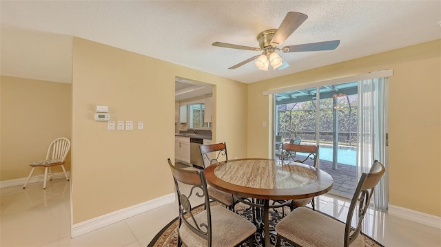 dining area featuring baseboards, ceiling fan, and a textured ceiling