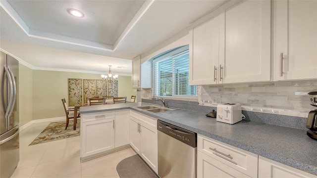 kitchen with white cabinets, stainless steel appliances, crown molding, and a sink