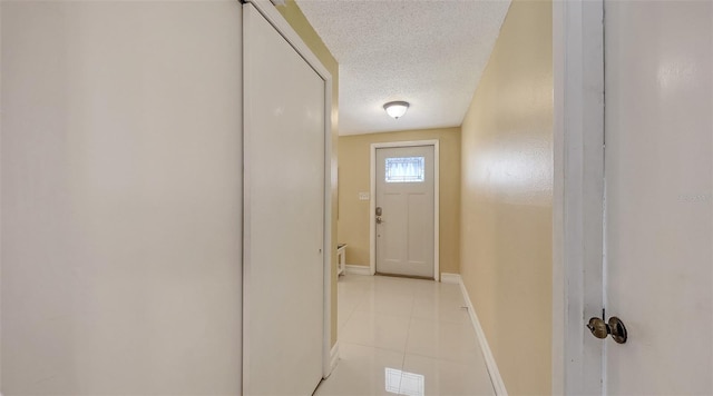 doorway to outside with baseboards, visible vents, a textured ceiling, and light tile patterned flooring