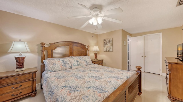 bedroom featuring visible vents, light tile patterned floors, a ceiling fan, and a textured ceiling