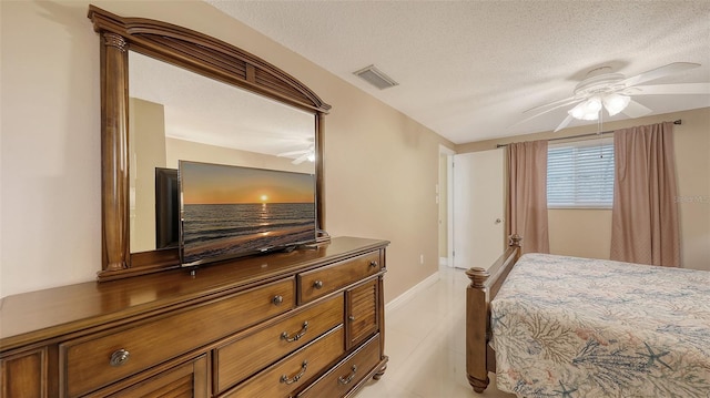 bedroom with light tile patterned flooring, ceiling fan, visible vents, baseboards, and a textured ceiling