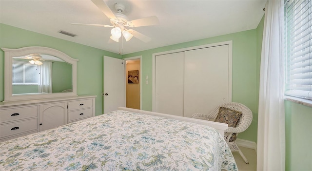 bedroom with a closet, visible vents, multiple windows, and baseboards