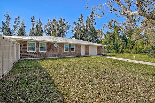 ranch-style home featuring a garage, a front yard, aphalt driveway, and brick siding