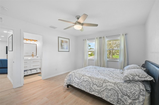 bedroom featuring visible vents, ensuite bathroom, baseboards, a ceiling fan, and light wood-style flooring