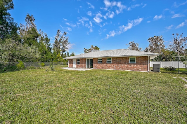 back of house featuring a lawn, a fenced backyard, a patio area, and brick siding
