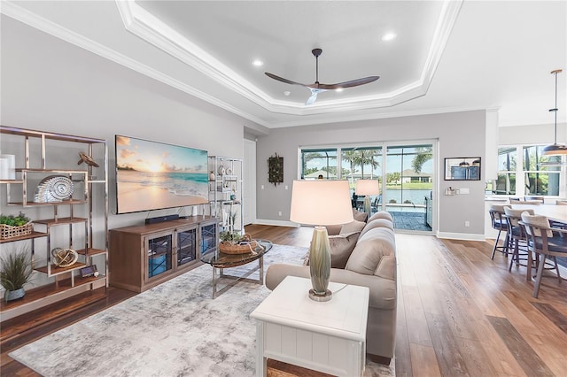 4625 Foxtail Dr, Parrish, FL 34219 - living room featuring a raised ceiling, ceiling fan, plenty of natural light, wood-type flooring, and crown molding