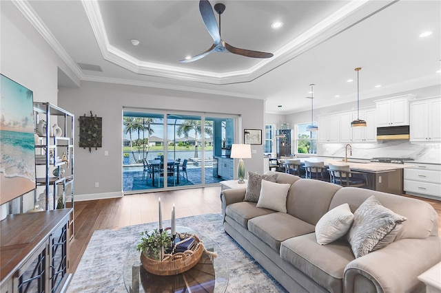 4625 Foxtail Dr, Parrish, FL 34219 - living room with a ceiling fan, wood finished floors, a tray ceiling, recessed lighting, and crown molding