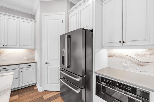 4625 Foxtail Dr, Parrish, FL 34219 - kitchen with stainless steel appliances, ornamental molding, light wood-type flooring, white cabinetry, and light countertops