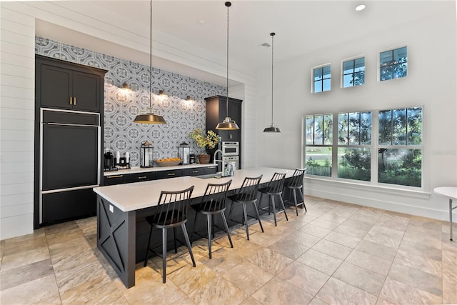 4625 Foxtail Dr, Parrish, FL 34219 - kitchen with paneled built in fridge, light countertops, a center island with sink, a sink, and a breakfast bar area