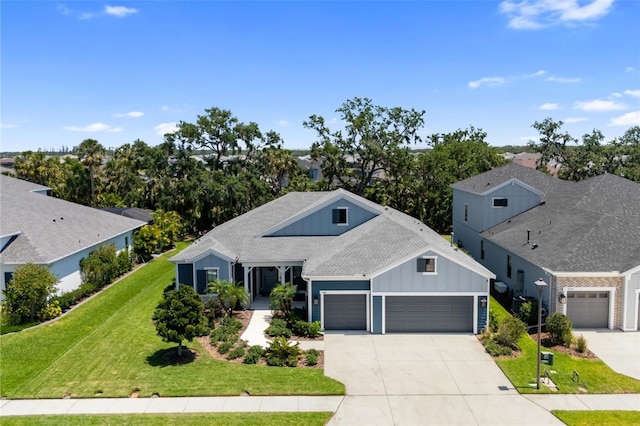 4308 Fly Rod Ter, Parrish, FL 34219 - ranch-style home with board and batten siding, driveway, a front yard, an attached garage, and a shingled roof