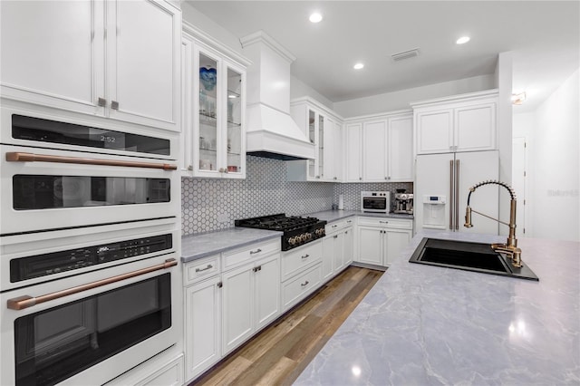 4308 Fly Rod Ter, Parrish, FL 34219 - kitchen featuring visible vents, decorative backsplash, white appliances, white cabinets, and a sink