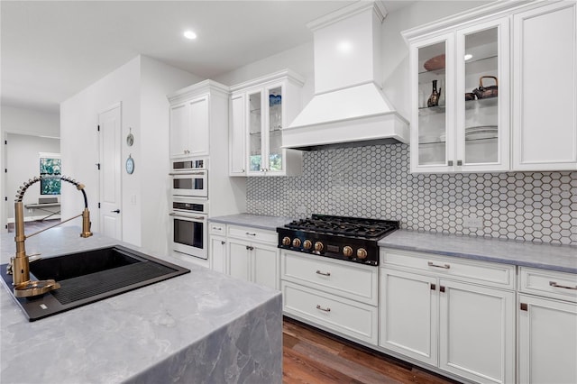 4308 Fly Rod Ter, Parrish, FL 34219 - kitchen featuring a sink, white cabinets, black cooktop, and premium range hood