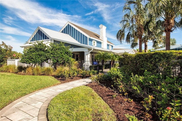4308 Fly Rod Ter, Parrish, FL 34219 - view of front facade featuring metal roof, a chimney, fence private yard, and a front lawn