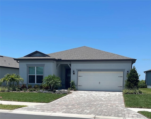 8752 Coastal Key Way, Parrish, FL 34219 - single story home with stucco siding, decorative driveway, a garage, and a front lawn