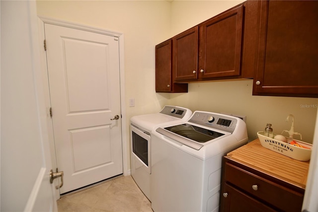 17817 Woodland Ct, Punta Gorda, FL 33982 - washroom with separate washer and dryer, cabinet space, and light tile patterned flooring