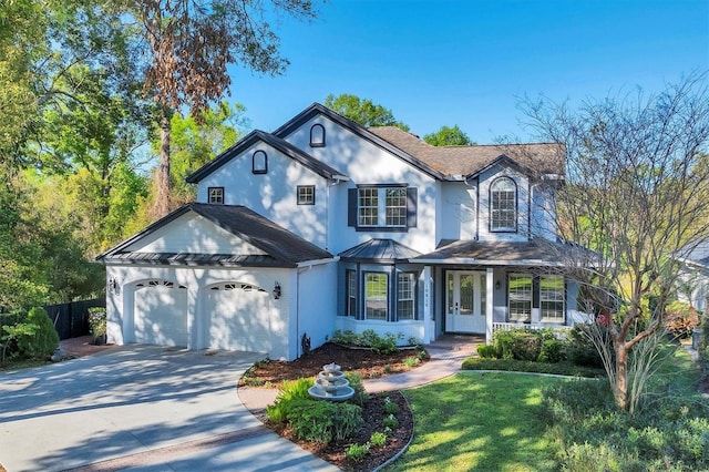 traditional home with fence, an attached garage, concrete driveway, a front yard, and stucco siding