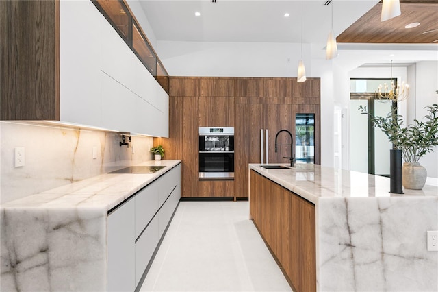 kitchen with white cabinetry, modern cabinets, a sink, and double oven