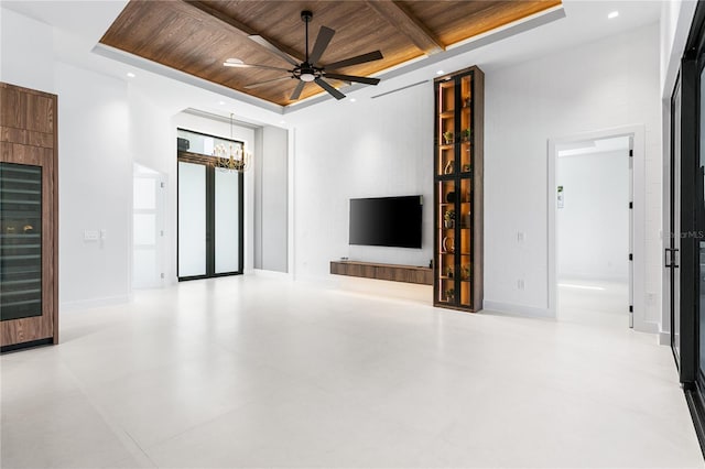 unfurnished living room featuring baseboards, recessed lighting, ceiling fan with notable chandelier, a tray ceiling, and wood ceiling