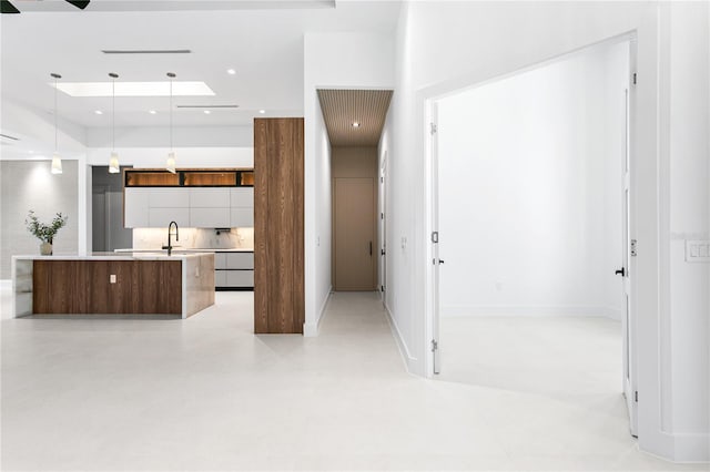 kitchen featuring light countertops, concrete flooring, recessed lighting, a spacious island, and modern cabinets