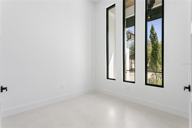 spare room featuring baseboards and finished concrete floors