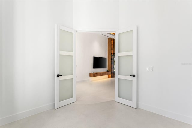 spare room with baseboards and finished concrete floors