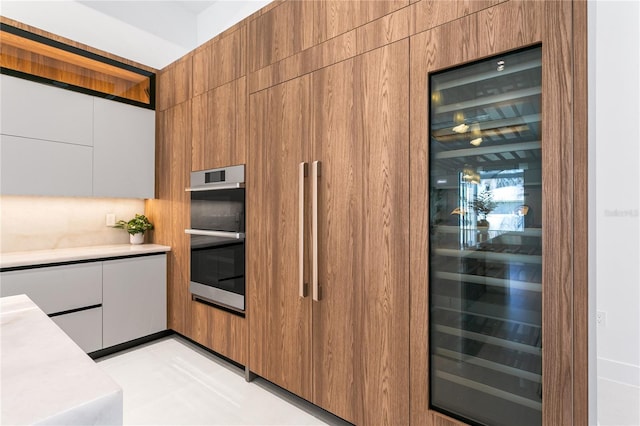 kitchen featuring white cabinetry, light countertops, stainless steel double oven, and modern cabinets