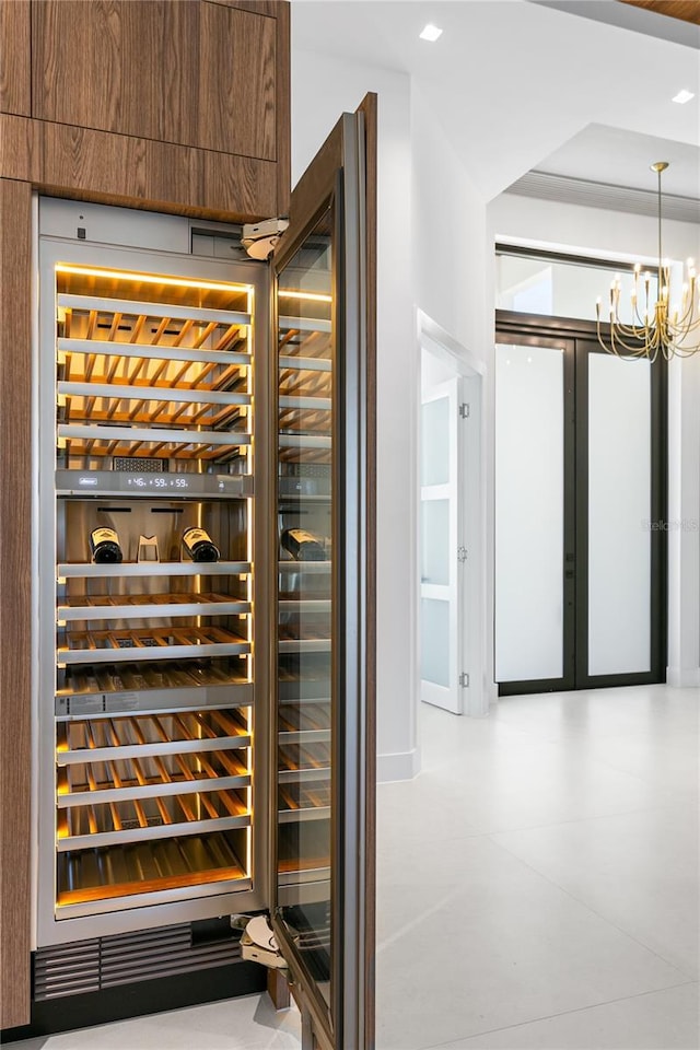 wine cellar featuring a chandelier and beverage cooler