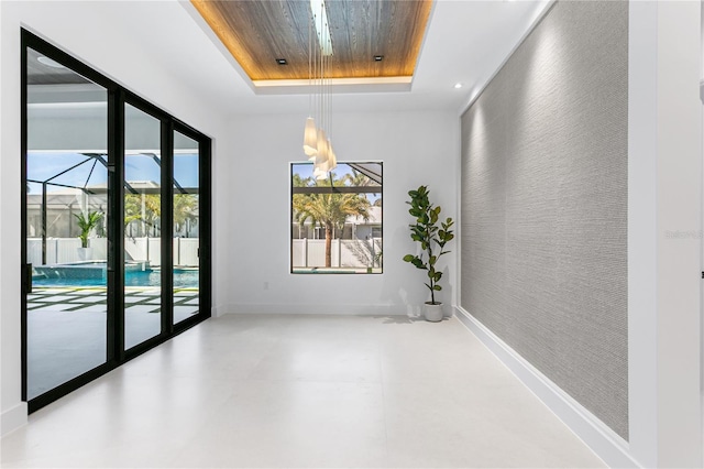 unfurnished room with a tray ceiling, recessed lighting, baseboards, a chandelier, and wood ceiling