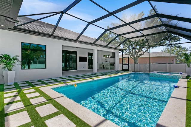 view of pool with a patio, a pool with connected hot tub, and glass enclosure