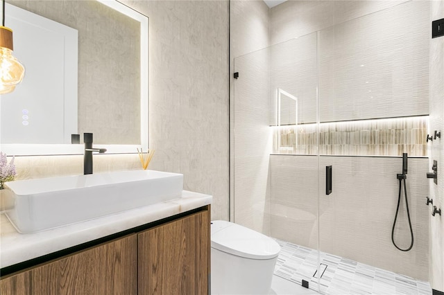 bathroom with toilet, a stall shower, and vanity