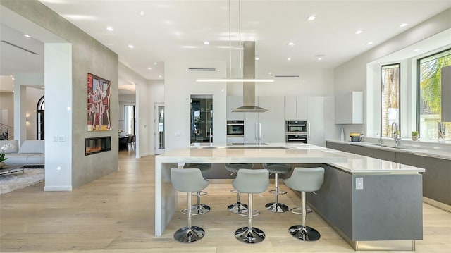 1540 Hillview Dr, Sarasota, FL 34239 - kitchen featuring light countertops, a sink, light wood finished floors, modern cabinets, and white cabinets