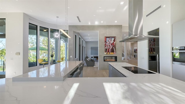 1540 Hillview Dr, Sarasota, FL 34239 - kitchen with black electric stovetop, island exhaust hood, and modern cabinets