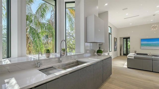 1540 Hillview Dr, Sarasota, FL 34239 - kitchen with modern cabinets, a sink, light wood-style floors, and a wealth of natural light