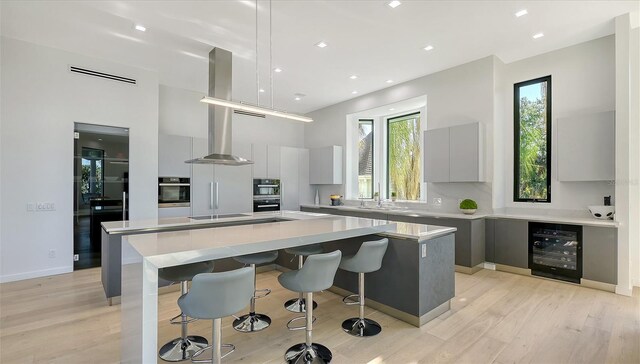 1540 Hillview Dr, Sarasota, FL 34239 - kitchen with tasteful backsplash, a breakfast bar area, a center island, wine cooler, and modern cabinets